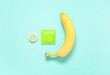 Fresh banana and condoms on turquoise background. Sex education concept