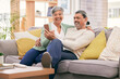 © LuneVA/peopleimages.com - Phone, happy and mature couple on sofa with smile for social media post, internet and browse website. Marriage, love and man and woman on smartphone in living room for bonding, funny meme and relax