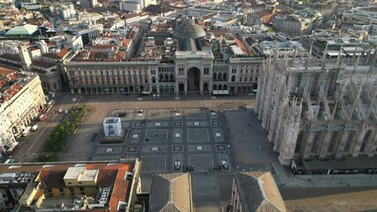 Wall Mural - Europe, Italy, Milan - Aerial view of Piazza Duomo, gothic Cathedral in downtown center city. Drone aerial view of the gallery and rooftops during sunrise - Duomo Unesco Heritage sightseeing 