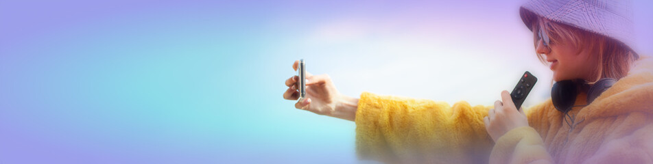 Young pretty woman social media influencer. Portrait of stylish good-looking Teenage girl blogger, in a yellow fur coat, taking selfie, hold mobile phone.