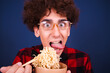 Funny attractive student eats delicious Chinese noodles.
