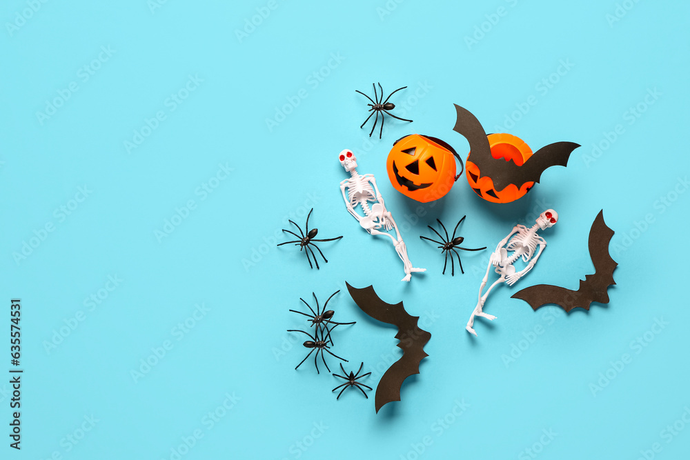 Composition with skeletons, pumpkins, paper bats and spiders for Halloween celebration on blue background