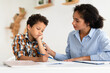 © Prostock-studio - Mom Comforting Unhappy Schoolboy Son Having Issue With Homework Indoors