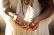 © Jasmina - Woman with boho jewellery holding a feather in her hands close up