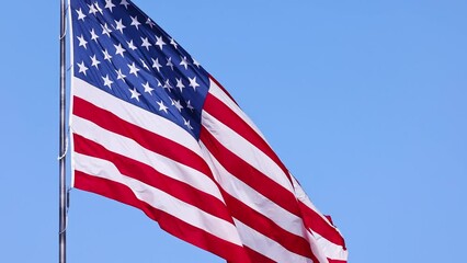 Wall Mural - us flag on a flagpole blowing in the breeze.