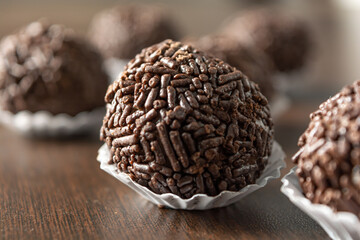 brazilian brigadeiro (brigadier) with chocolate sprinkles over wooden table. traditional brazilian candy for party dessert