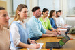 © JackF - Woman sitting at table and handwriting. University students sitting in a row in class room.