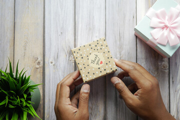 hand putting a thank you sticker on a gift box 