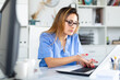 © JackF - Mexican female doctor in uniform is working behind laptop in hospital