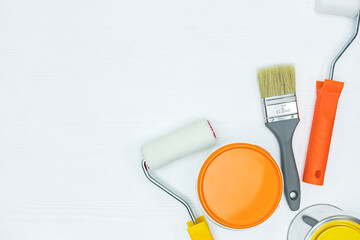 Sticker - painting tools on white desk. tins with paints, paint brushes and rollers. top view.