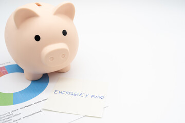  Concept of emergency savings fund. A piggy bank with paper note Pension Plan. Piggy bank and graph for saving emergency money. 