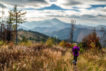 Wall Mural - Girl hiker on autumn moutain trail