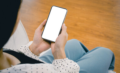 Poster - Mockup image, a woman holding black smartphone with blank white screen at home or office