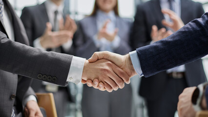 businessman and businesswoman shaking hands in hallway.