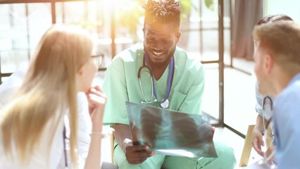 Wall Mural - Medical staff sitting at the table discussing x-ray