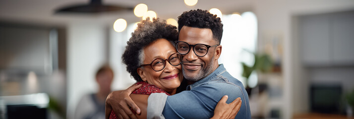 Senior woman embracing her adult son against the backdrop of a living room