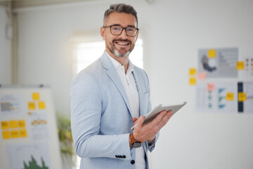 Portrait of mature man in office with tablet, smile and research for business website, online report or social media. Internet, digital app and businessman with workshop, web schedule and confidence.