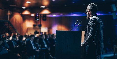 Wall Mural - speaker giving a talk on corporate business conference. unrecognizable people in audience at confere