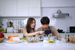 © Suney - Young couple is livestreaming in kitchen.