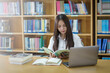 © EduLife Photos - Portrait of an Asian girl college student studying in library doing project assignment and preparing for examination