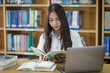 © EduLife Photos - Portrait of an Asian girl college student studying in library doing project assignment and preparing for examination