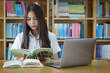 © EduLife Photos - Portrait of an Asian girl college student studying in library doing project assignment and preparing for examination
