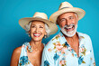 © ADDICTIVE STOCK - Generative AI image of portrait of cheerful senior couple with floral clothes looking away while standing closely together against blue backdrop