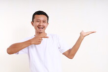 Excited Asian Funny Man Presenting Something On His Hand. Isolated On White Background