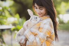 Relationships Of Cheerful Rabbit And Happy Young Human Girl, Asian Woman Holding And Carrying Cute Rabbit With Tenderness And Love. Friendship With Cute Easter Bunny. Happy Of Easter's Day