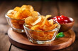 Potato chips snacks in glass bowls on wooden background