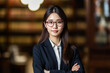 © XaMaps - Engaging, young Asian woman attorney confidently sporting glasses and crossed-arms, conveying strong professional credibility. Perfect to enhance corporate aesthetics.