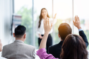 Business person raising hand during seminar. Hand up in conference asking to answer a question in business meeting room and seminar class.