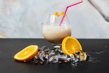 a drink in a tall glass with orange slices and ice on the side