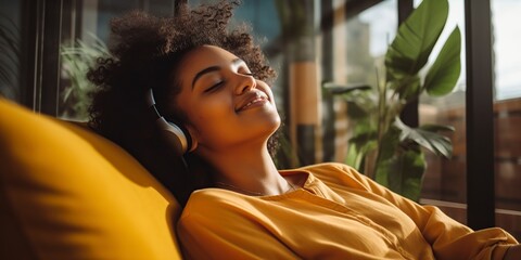 happy african american woman relaxing on sofa at home