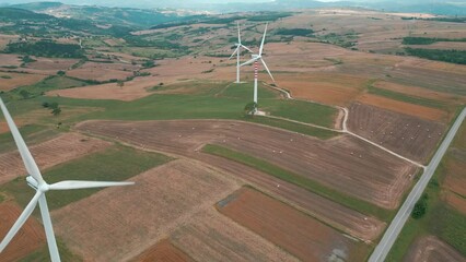 Sticker - Drone shot over a windmill farm with colorful fields