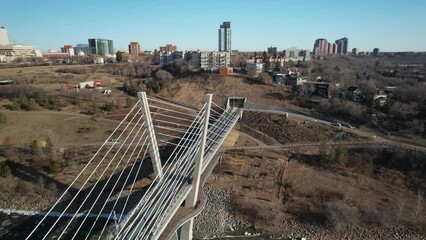 Poster - Aerial of a calm river under the bridge with buildings against the blue sky in the background