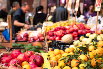 Fruit and vegetable stall in a street market in Naples in Italy. Signs with prices in the background, oranges, bananas, pomegranates.