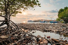 Tranquil Scene Of Sailboats Moored At The Rocky Shore At Sunset In Thailand