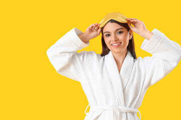 Sticker - Young woman in gown with sleeping mask on yellow background