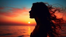 Young Woman S Silhouette Against A Sunset Over The Sea