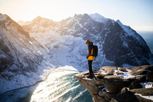 Traveler Standing On Cliff Against Mountains
