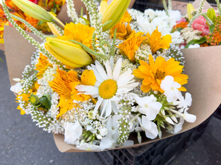 Wall Mural - A view of a white and yellow floral bouquet, on display at a local farmers market.