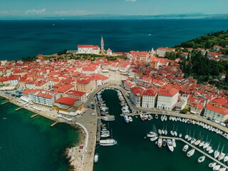 Canvas Print - Scenic view of a small island with a plethora of boats surrounding it in Piran, Slovenia