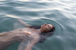 © Anna Berkut/Stocksy - mental health, portrait of sad calm woman floating in water, apathy