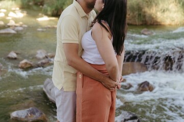 Wall Mural - the man and woman are posing by a waterfall together in this photo