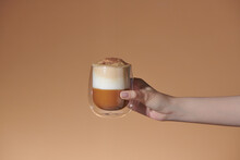 Hand Hold Ice Latte Coffee In A Glass With Cream On Bottom 