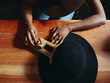 © Iryna Shepetko/Stocksy - Close-up of hands and hat. woman hat maker in a workshop space.