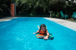 © Maria Manco/Stocksy - Girl boogie boards in backyard pool
