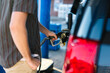 © Maria Manco/Stocksy - Closeup  of man pumping gas
