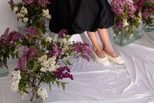 Anonymous Woman In Fake Fur Slippers Standing Near Flower Bouquets